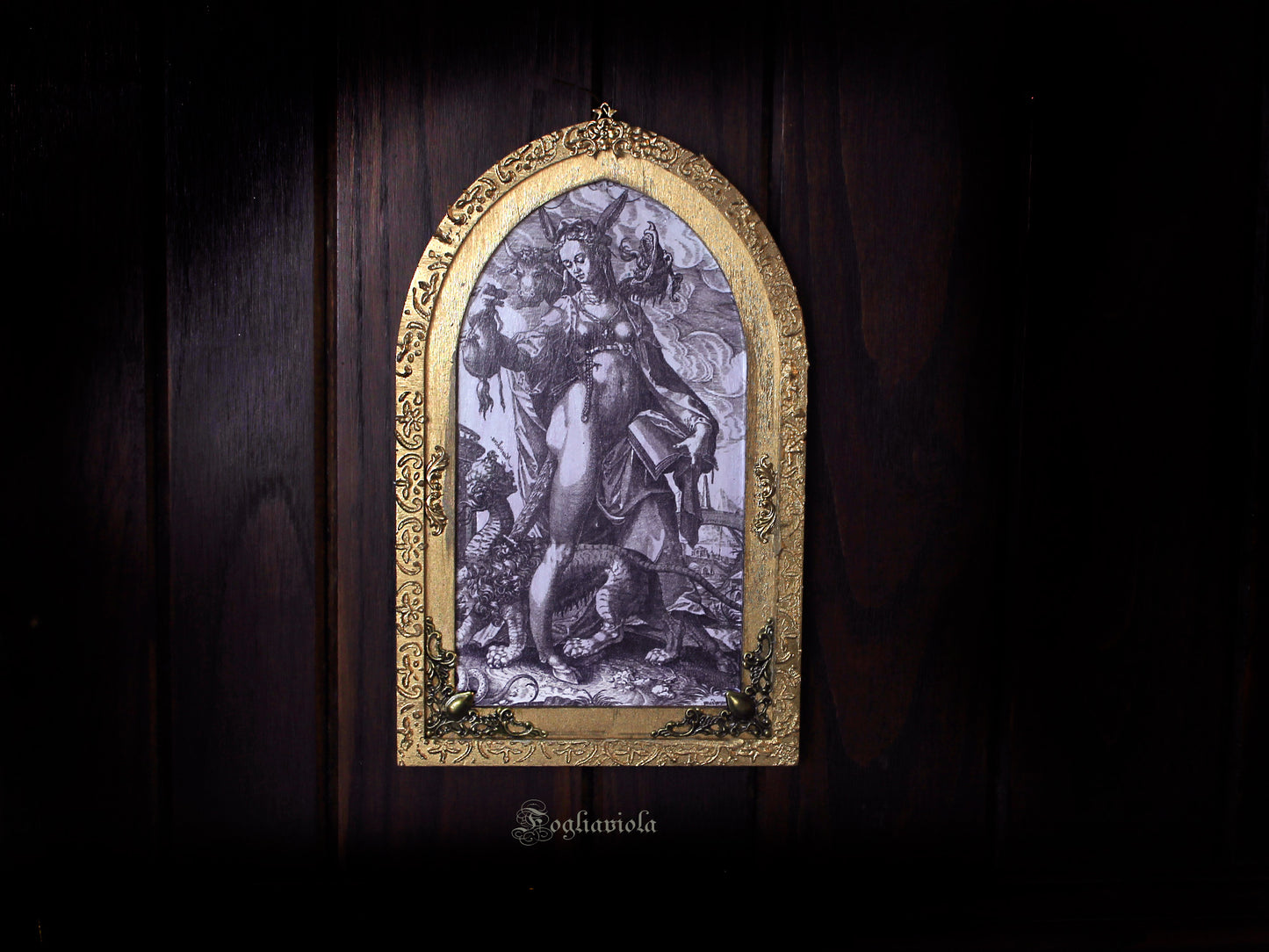 Tavola devozionale artigianale ad arco gotico: figura allegorica dell'Eresia con manticora, stampa antica su compensato sagomato, cornice dorata in rilievo. Fogliaviola.