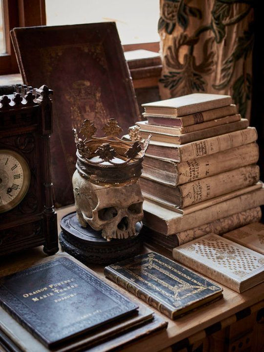 Dark Academia estetica gotica - scrivania con diari artigianali, candele e libri antichi