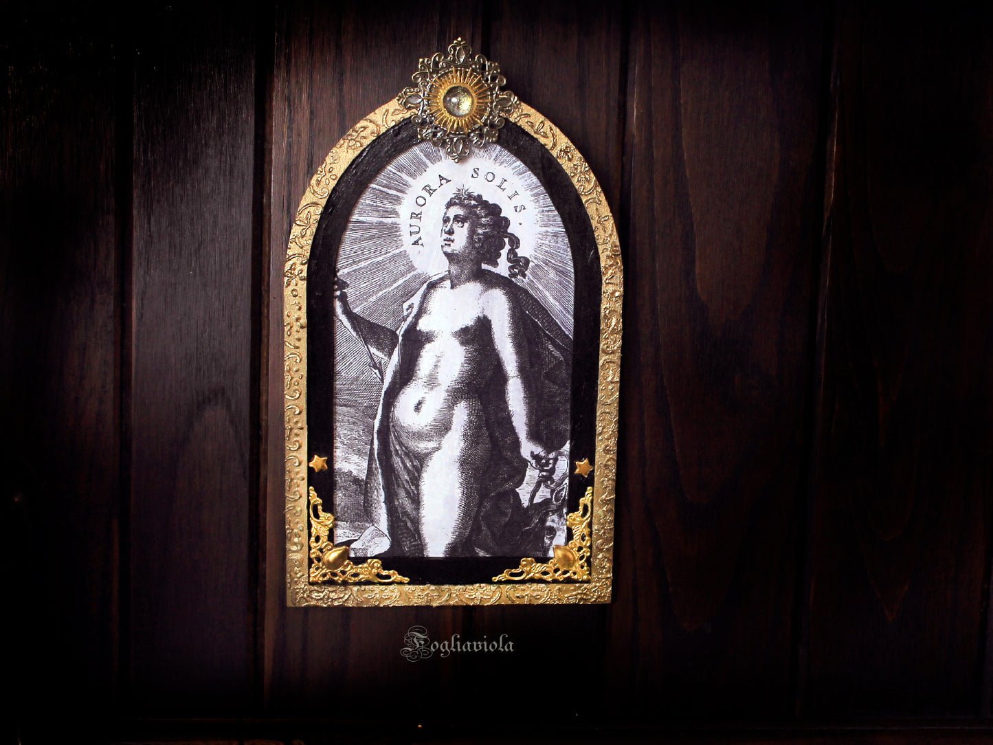 Tavola devozionale artigianale ad arco gotico: Aurora Solis, dea dell'alba, stampa antica su compensato nero, raggiera solare in ferro con cabochon in vetro, cornice dorata. Fogliaviola.