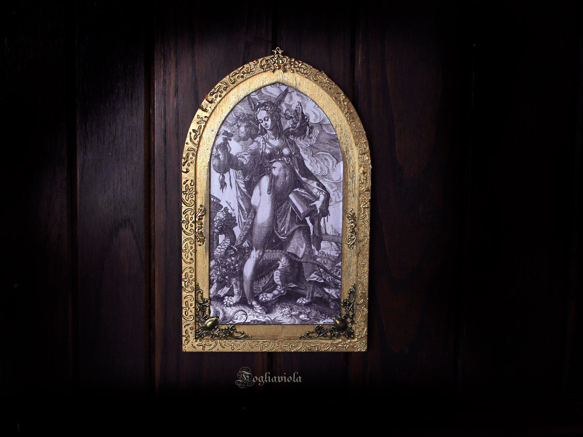 Tavola devozionale artigianale ad arco gotico: figura allegorica dell'Eresia con manticora, stampa antica su compensato sagomato, cornice dorata in rilievo. Fogliaviola.