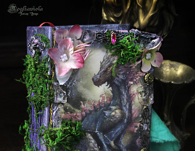 Dettaglio del diario fantasy con drago tra cristalli magici, muschio e fiori giurassici di Fogliaviola Design