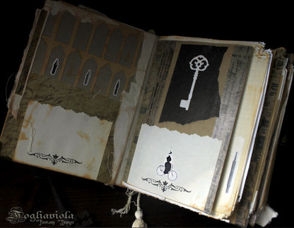 Dettaglio del diario artistico fatto a mano dalla copertina miniata con catena, lucchetto e chiave