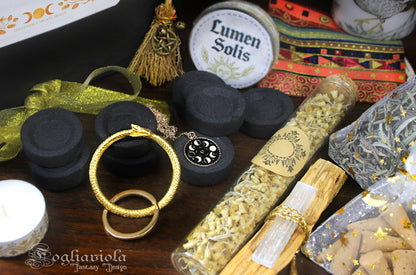 Dettaglio Litha Summer Box – portachiavi ouroboros dorato, collana fasi lunari, carboncini qualità muschio, fiala elicriso biologico e scatola incensi in grani