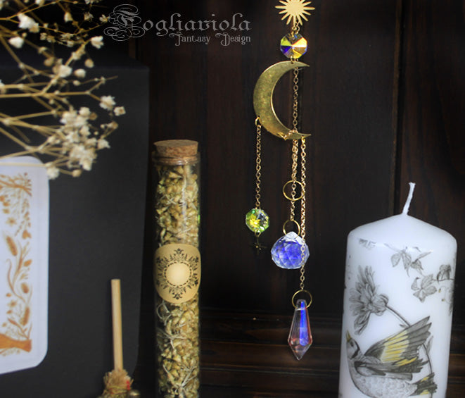 Dettaglio Litha Summer Box – suncatcher luna e cristalli sfaccettati dorato, fiala erbe biologiche Fogliaviola e candela cilindrica decorata a mano con uccellino